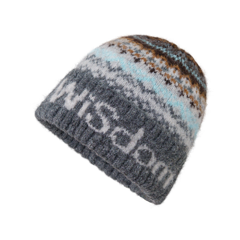 Dark gray knit beanie with blue and brown Fair Isle top and letter-style band