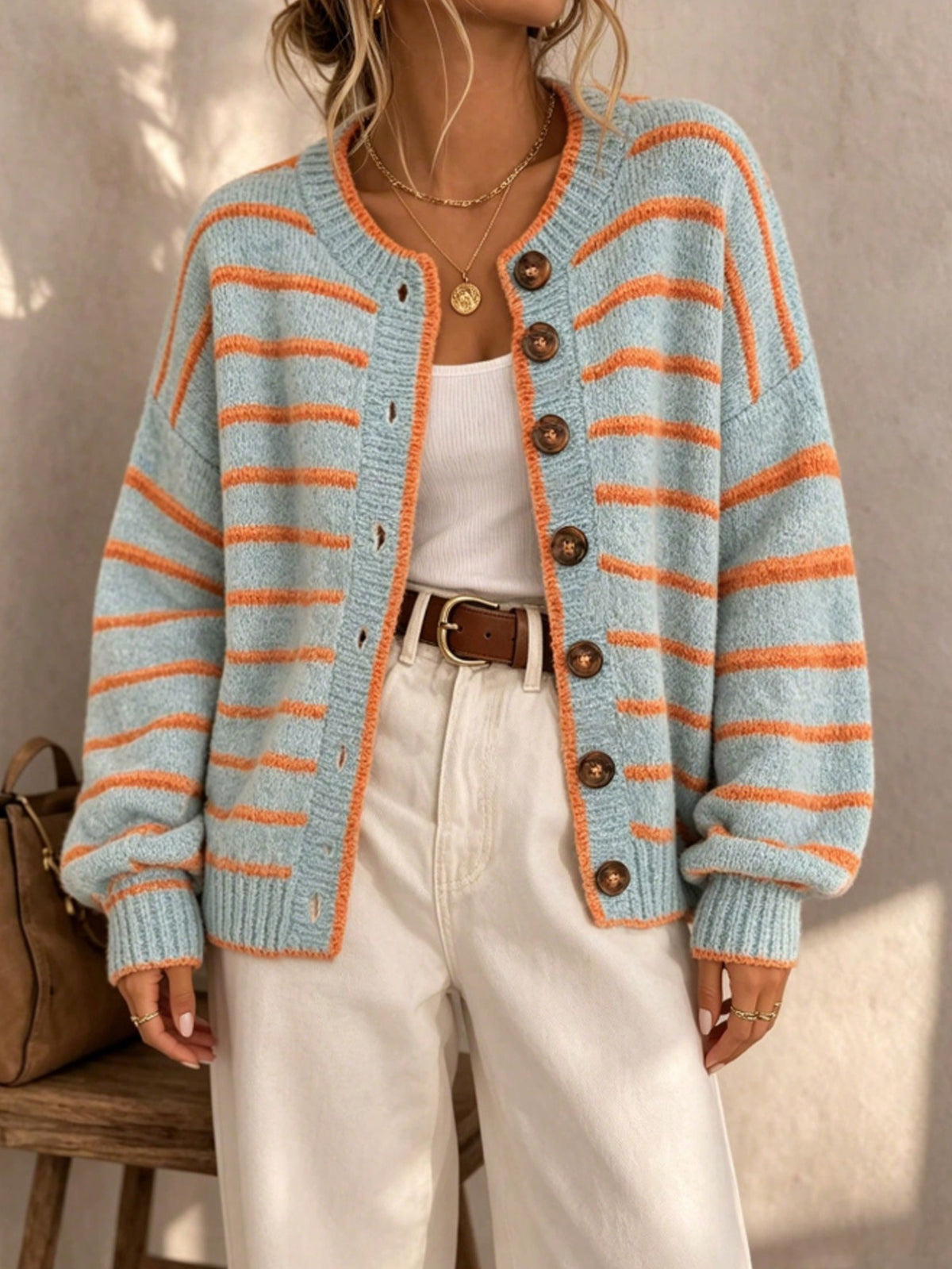 Light blue striped knit cardigan with orange stripes, dark buttons and relaxed fit