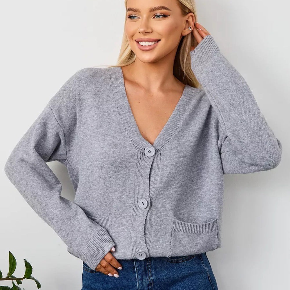 Women's grey knit V-neck cardigan with button front and side pockets, long sleeves
