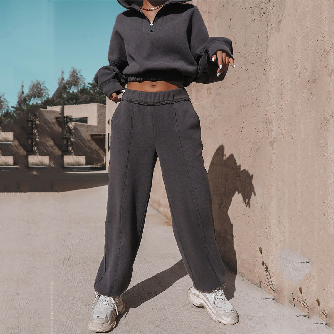Women's dark charcoal quarter-zip cropped sweatshirt with wide-leg joggers and sneakers