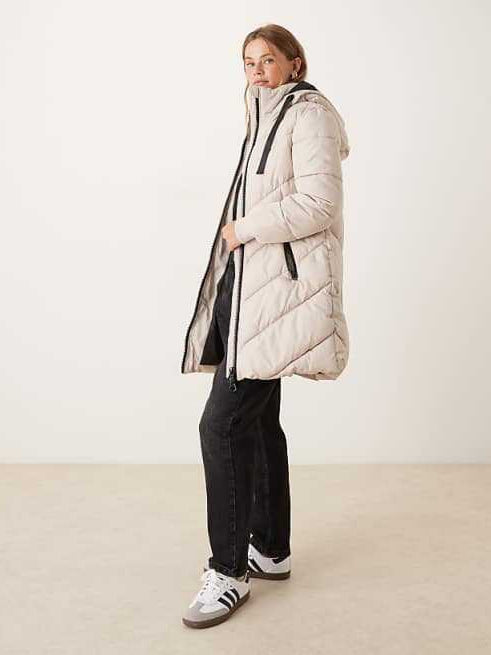 Light beige long puffer down jacket with hood, zip front, and long sleeves.