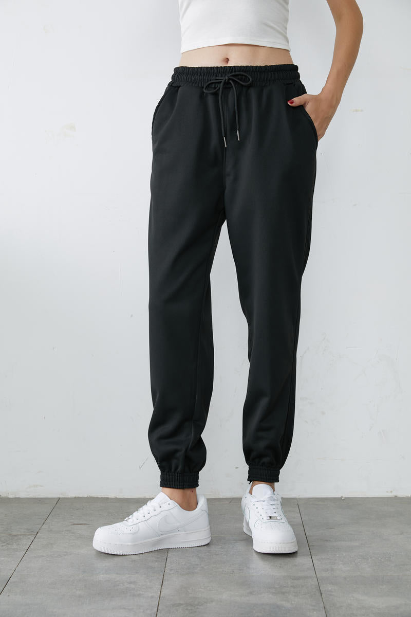 Black high-waisted jogger sweatpants with adjustable drawstring and tapered cuffs