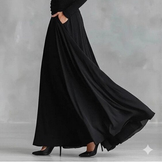 Black long-sleeve mermaid maxi dress with draped skirt and gathered waist, side view