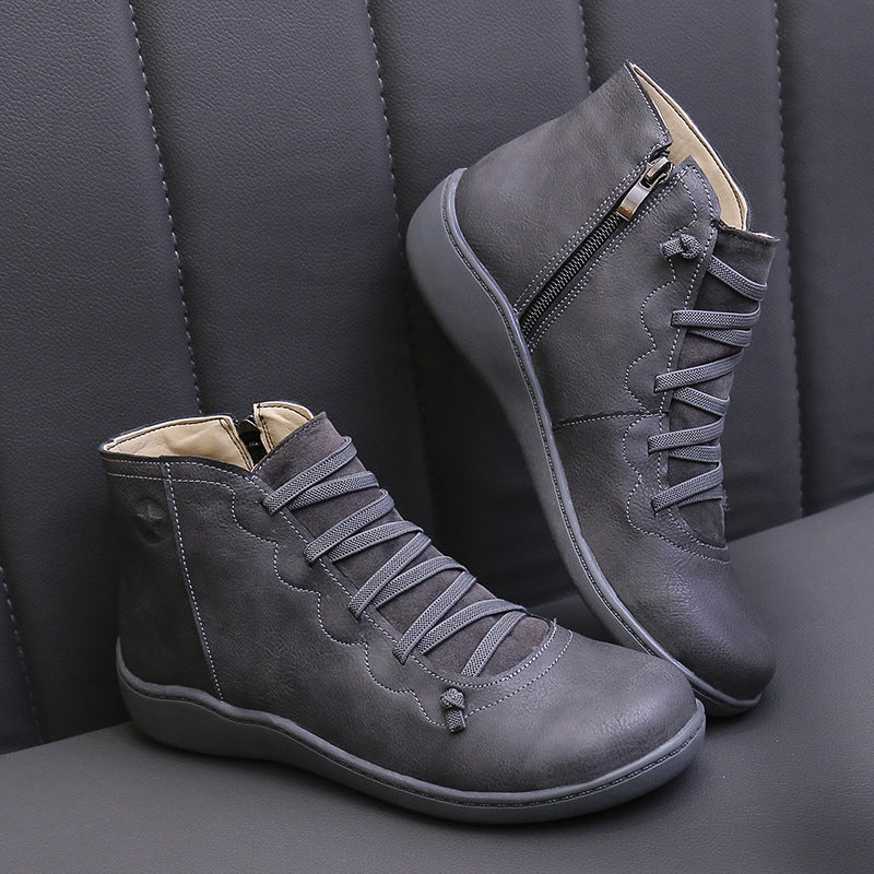 Gray women's ankle boots with flat soles, lace-up fronts and side zippers.