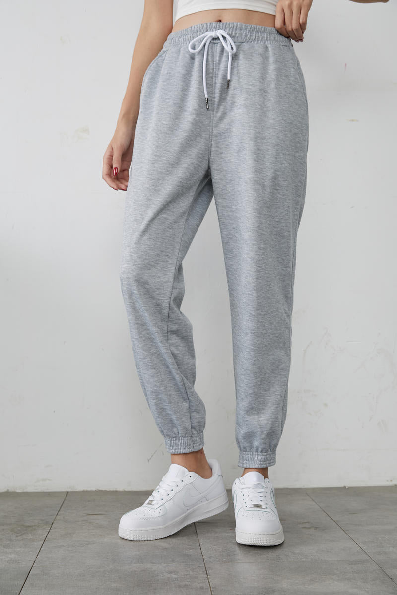 Gray high-waisted jogger sweatpants with drawstring waist and tapered elastic cuffs