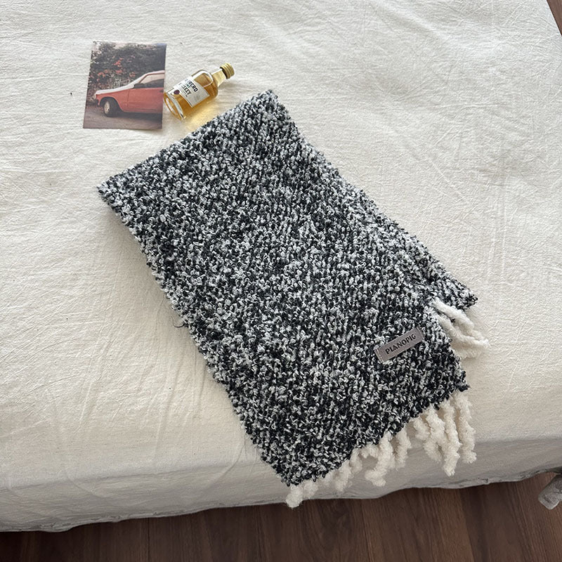 Dark gray chunky loop-knit scarf shawl with white fringed hem and brand tag label