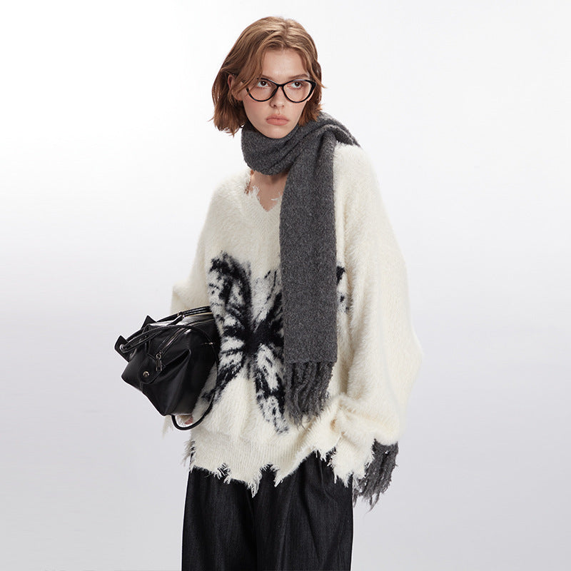 Oversized cream fuzzy sweater with round neck, long sleeves, and black butterfly motif