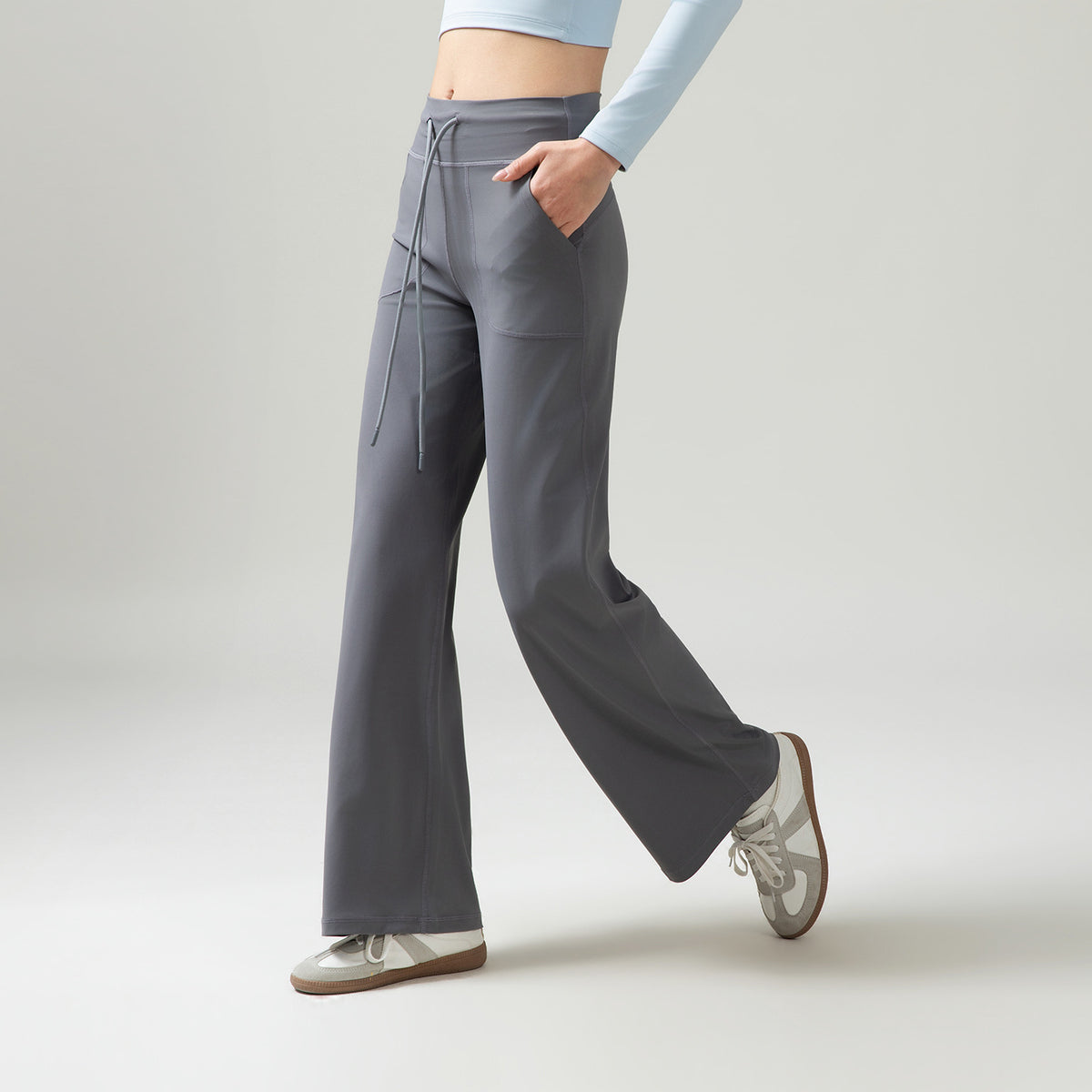 Women’s high-waisted wide-leg pants with drape, light gray, side drawstring ties and pockets.