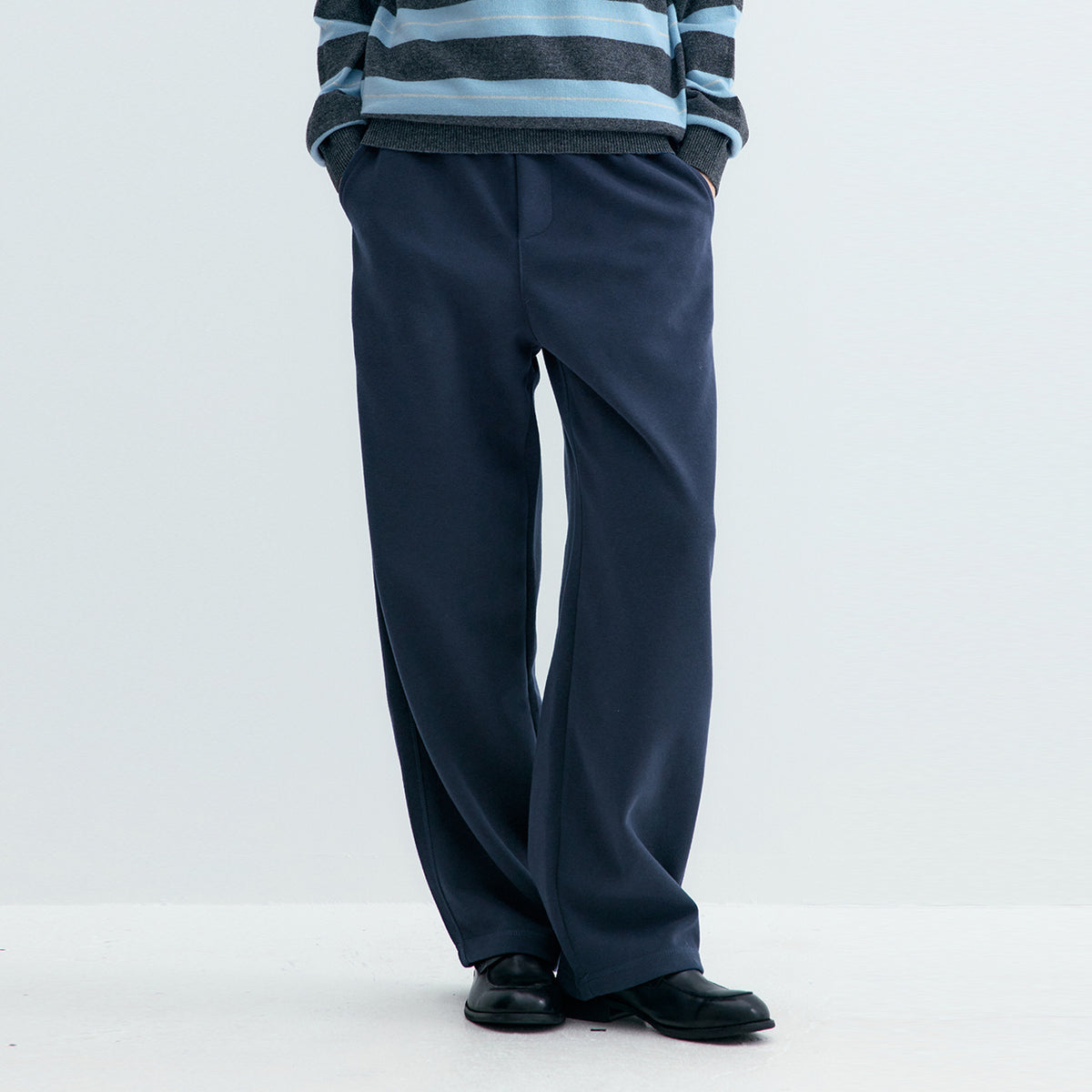 Dark blue sweatpants with straight wide legs and elastic waist, side view