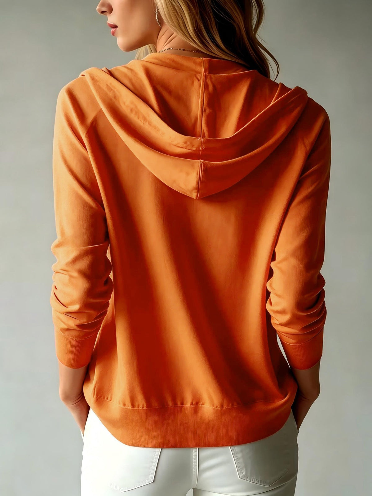 Women's orange knit hooded zip-up cardigan, rear view with hood drape