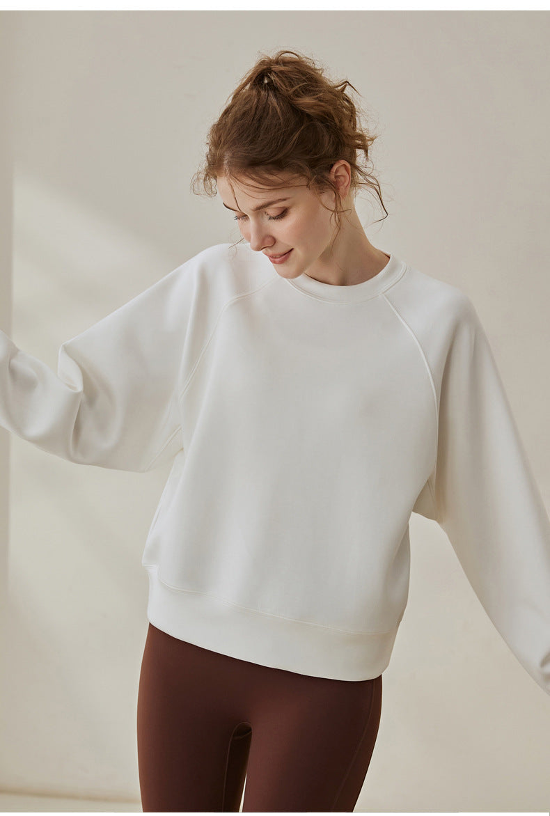 White round-neck sweatshirt with long sleeves and relaxed, roomy shoulder line