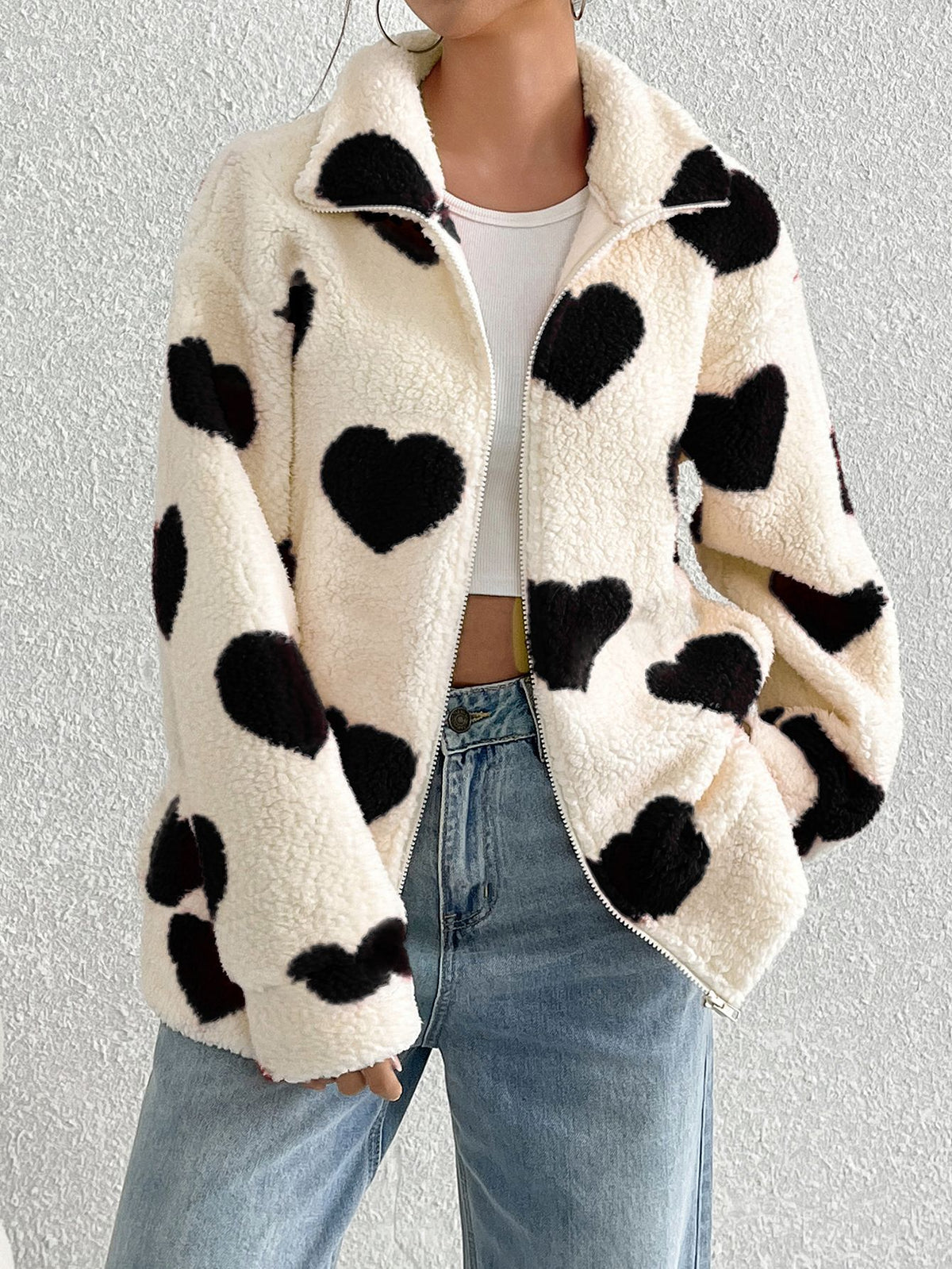Cream plush zip-up cardigan with black heart pattern, long sleeves, front zipper closure