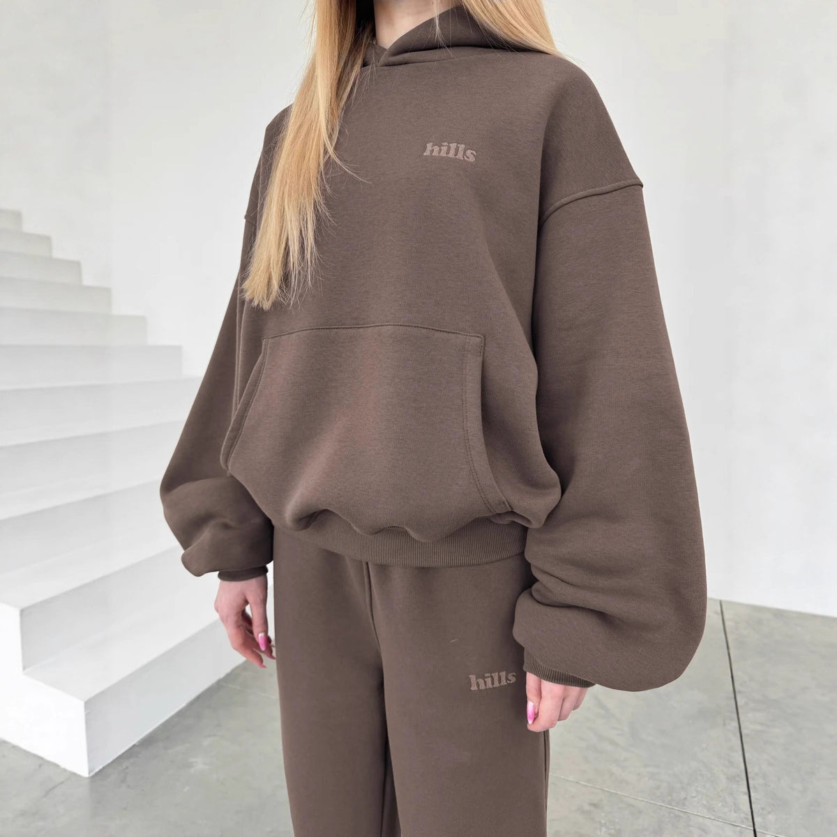 Dark brown hooded pullover sweatshirt with kangaroo pocket and small chest text print