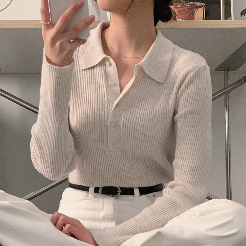 White knit polo collar long-sleeve top with button placket and subtle vertical ribbing.
