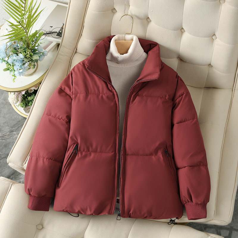 Short maroon puffer jacket with full zip, stand collar, and ribbed sleeve cuffs