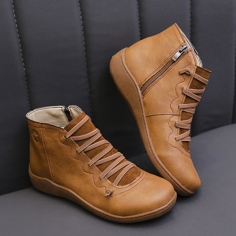 Tan women's ankle boots with flat soles, lace-up fronts and side zippers.