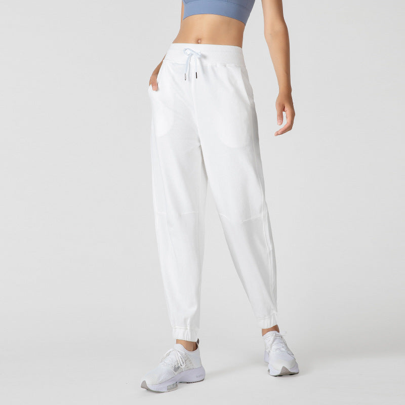 White jogger pants with a drawstring waist, side pockets, and cuffed hems