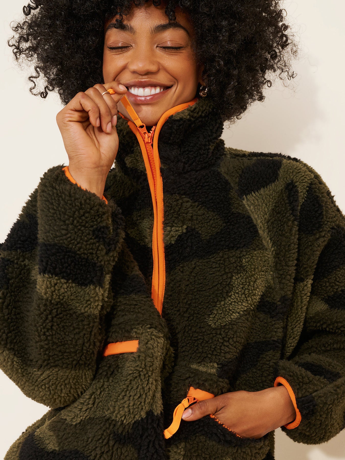 Olive camo teddy fleece jacket with orange zipper and contrast pocket trim