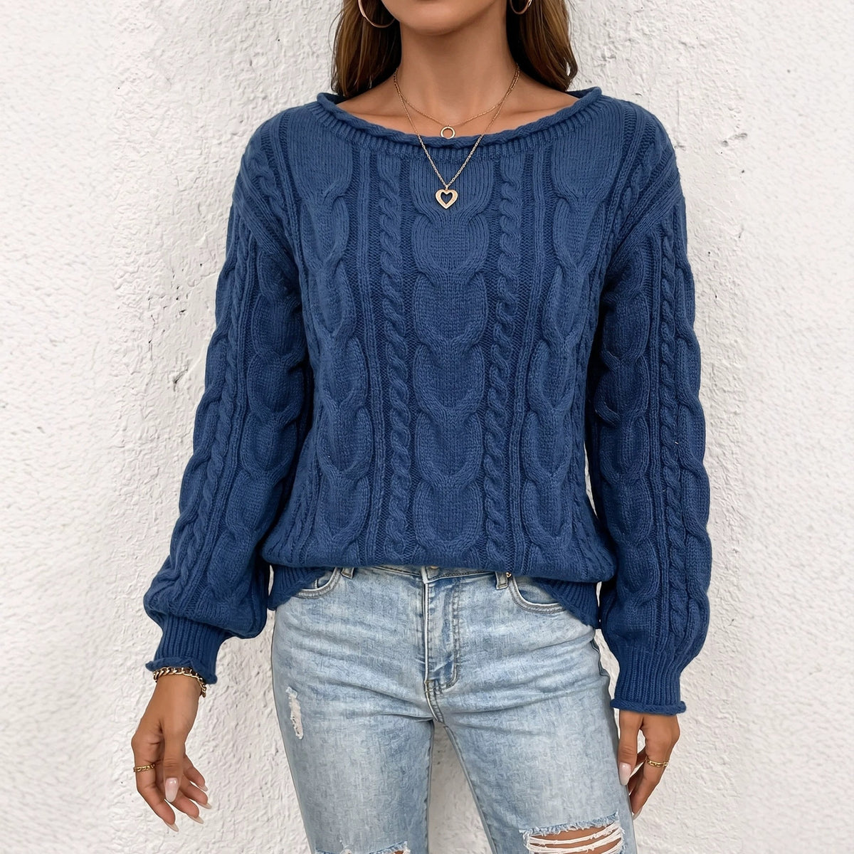 Blue cable-knit sweater with a wide neckline and long sleeves