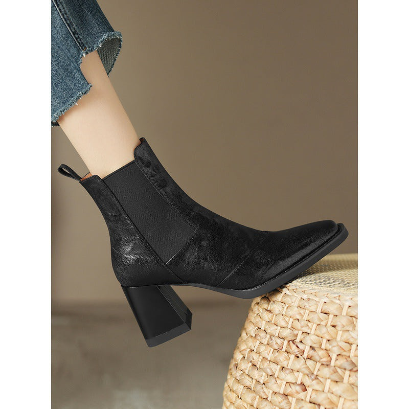 Black square-toe Chelsea boot shown in side profile with elastic panel and mid block heel