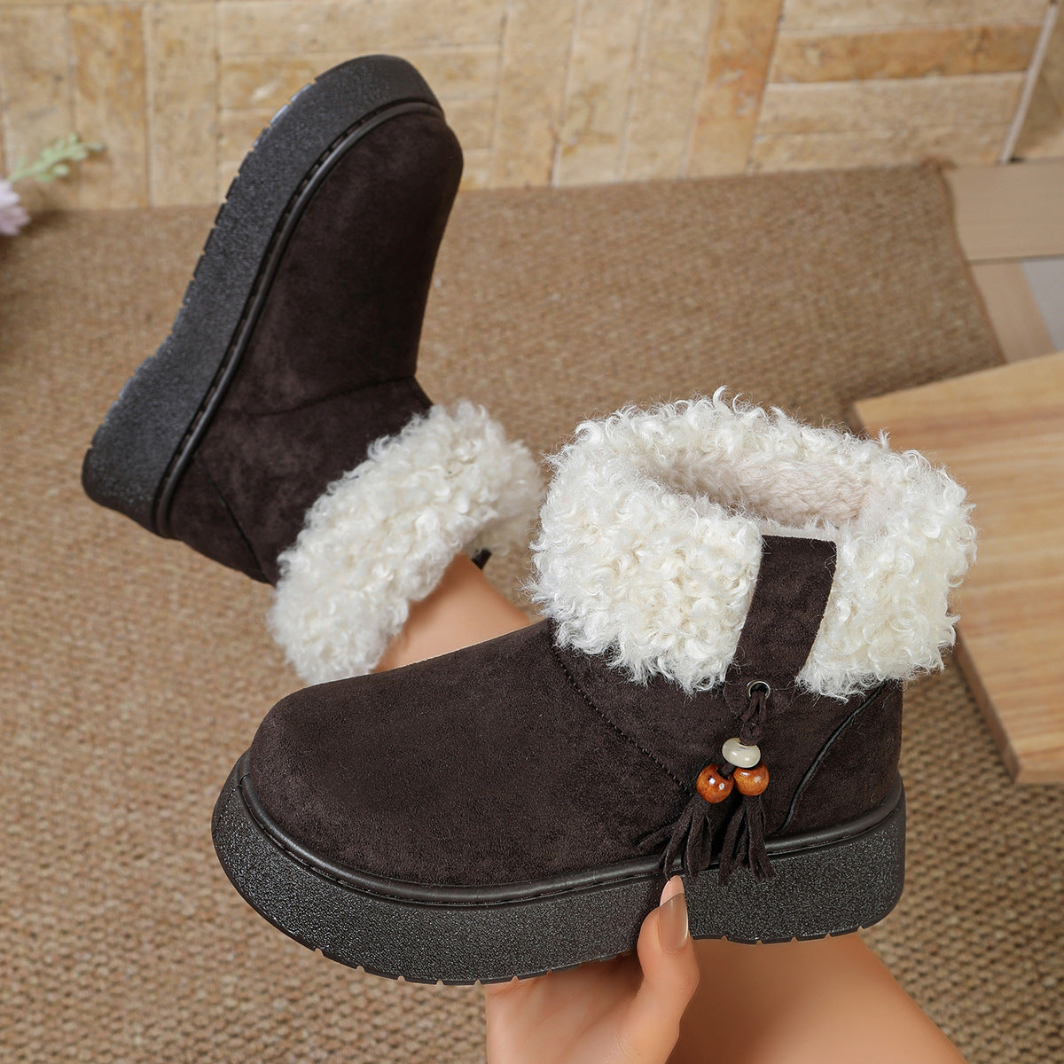 Black suede ankle boots with thick white faux-fur trim and tassel accent