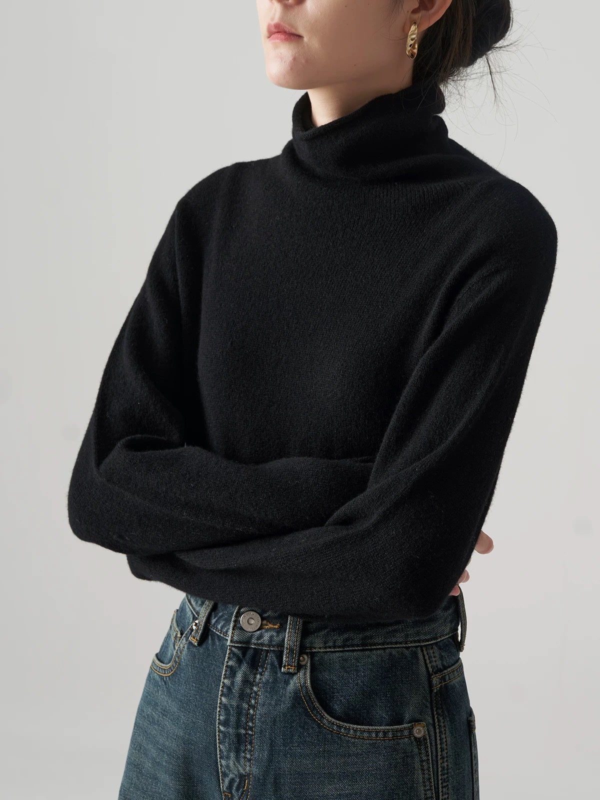 Black knit turtleneck sweater with high stack collar and long sleeves