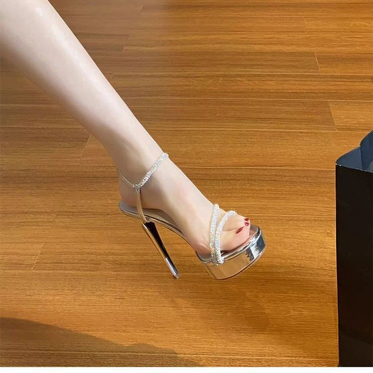 Silver rhinestone platform sandals with thin stiletto heel and ankle strap, side view