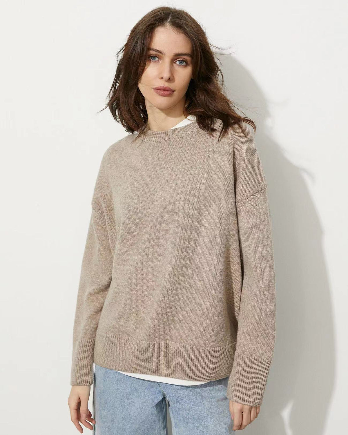 Beige relaxed-fit sweater with ribbed cuffs and hem, shown with jeans