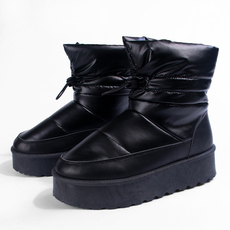 Women's black mid-top snow boots with lace bow details and thick platform soles
