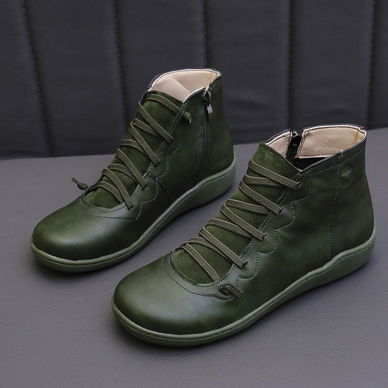 Dark green women's ankle boots with flat soles, lace-up fronts and side zippers.