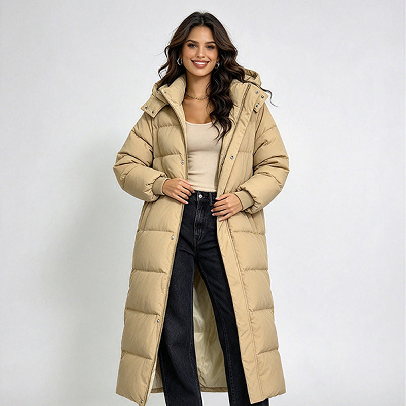 Women’s long beige hooded puffer coat with snap buttons and quilted panels.