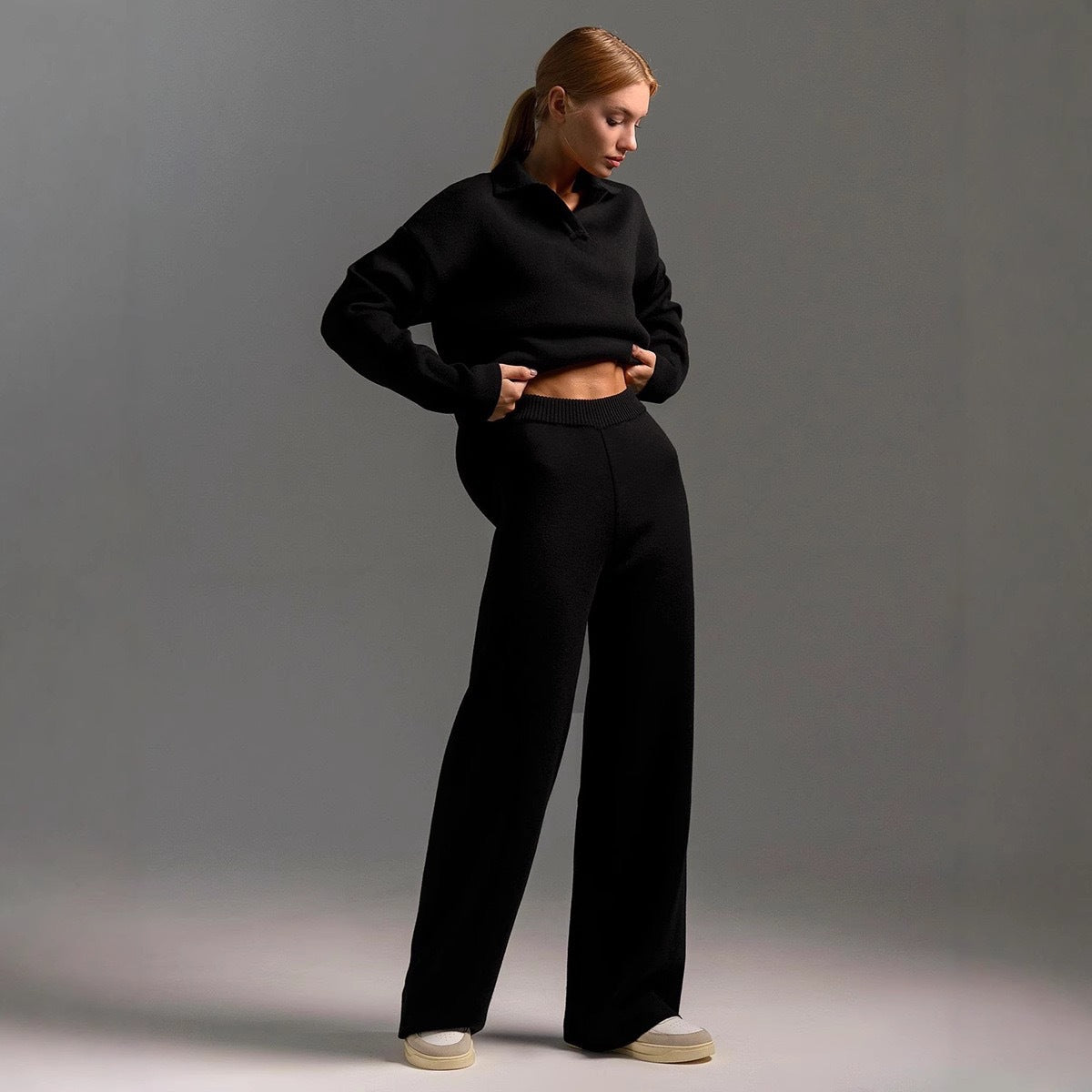 Black women's polo-neck two-piece set with wide-leg trousers, side view