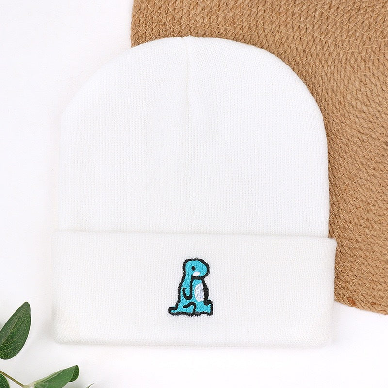 White knit beanie with blue animal embroidery on cuff