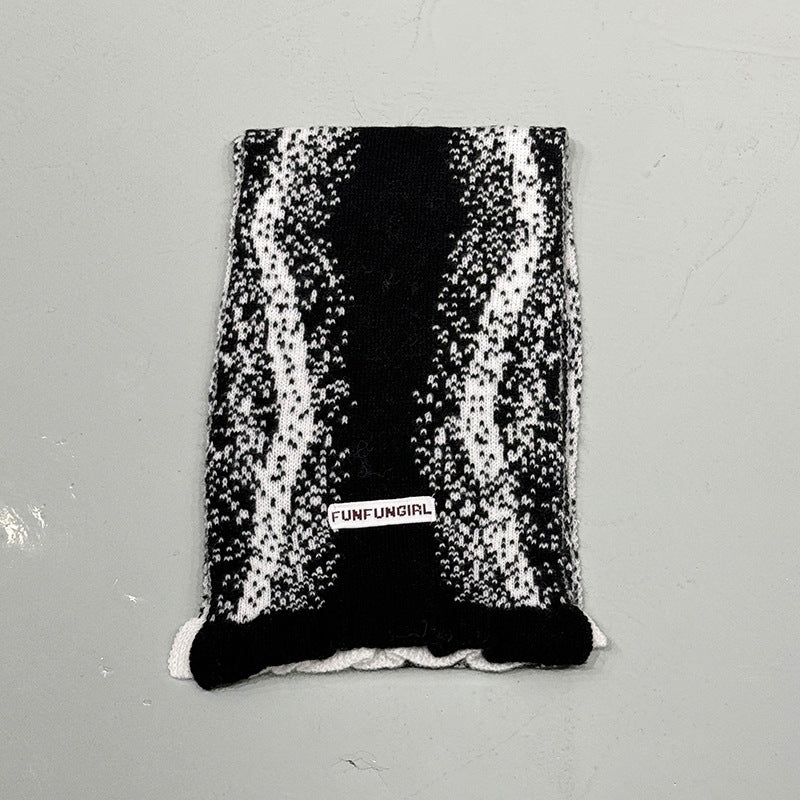 Black and white speckle knitted scarf with fringed bottom edge and label patch