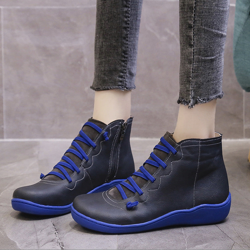 Black women's ankle boots with blue laces and soles, shown worn on feet.