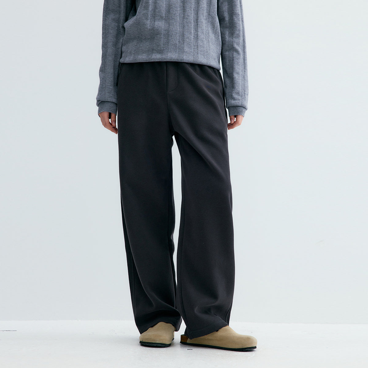 Black sweatpants from back view with straight wide legs and elastic waistband