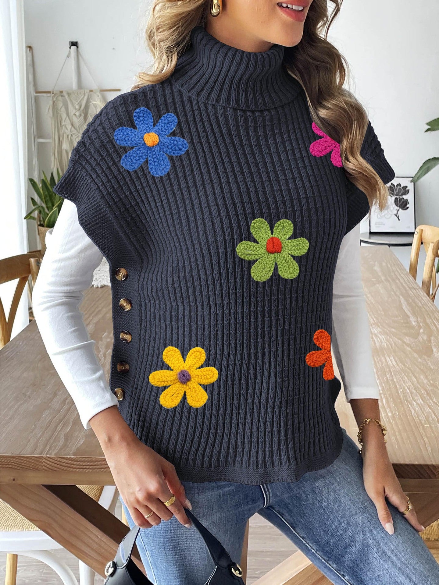Black ribbed high-neck sweater vest with colorful flower appliques and side buttons