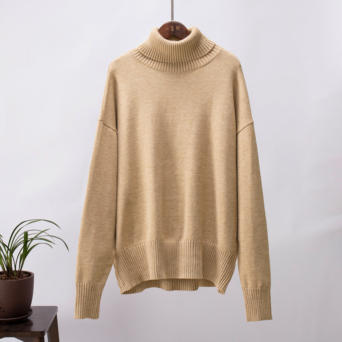Beige knit turtleneck pullover sweater with loose fit, ribbed hem and cuffs