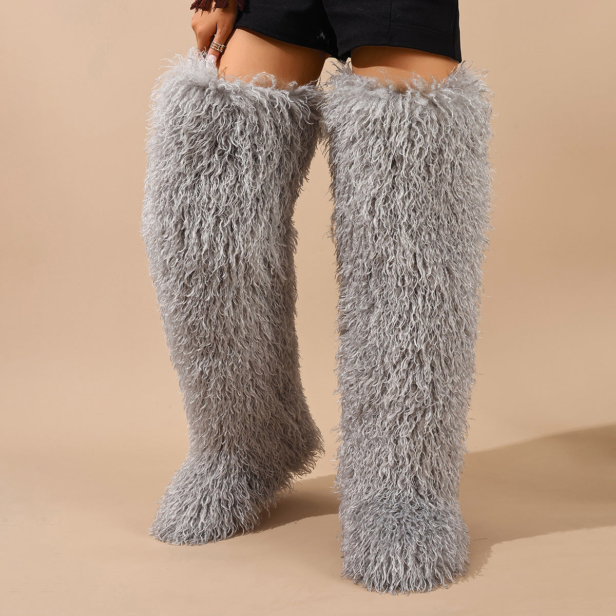 Light gray faux-fur thigh-high boots with shaggy pile, shown worn on both legs.