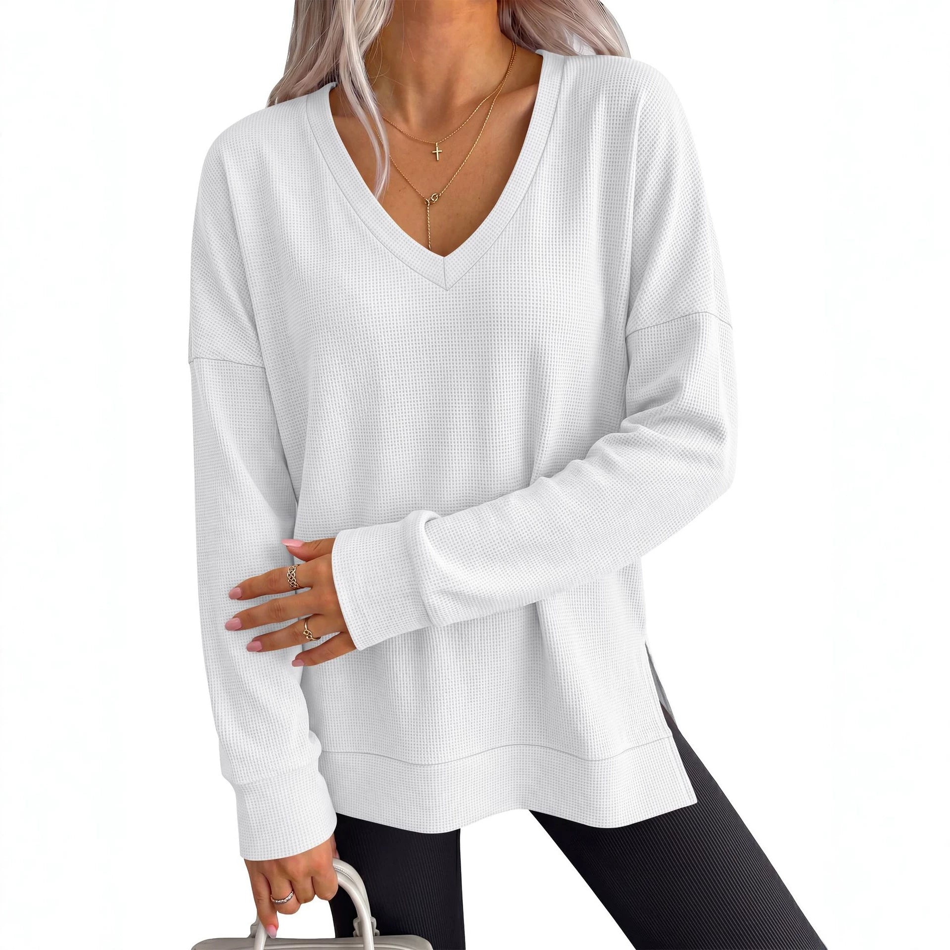 Women’s white V-neck long-sleeve waffle knit loose T-shirt top with side slits.