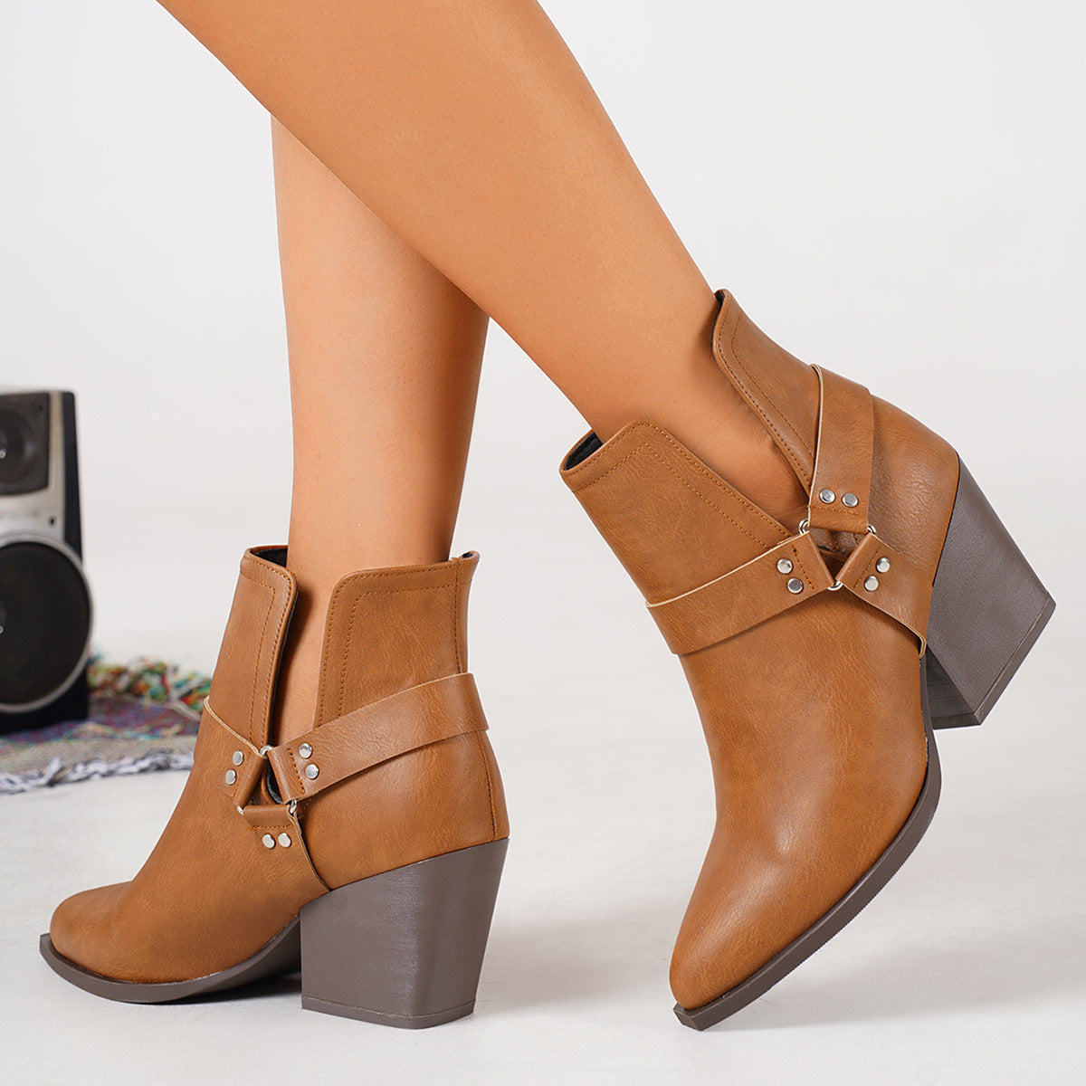 Brown cowboy ankle boots with side buckle straps and thick high block heel