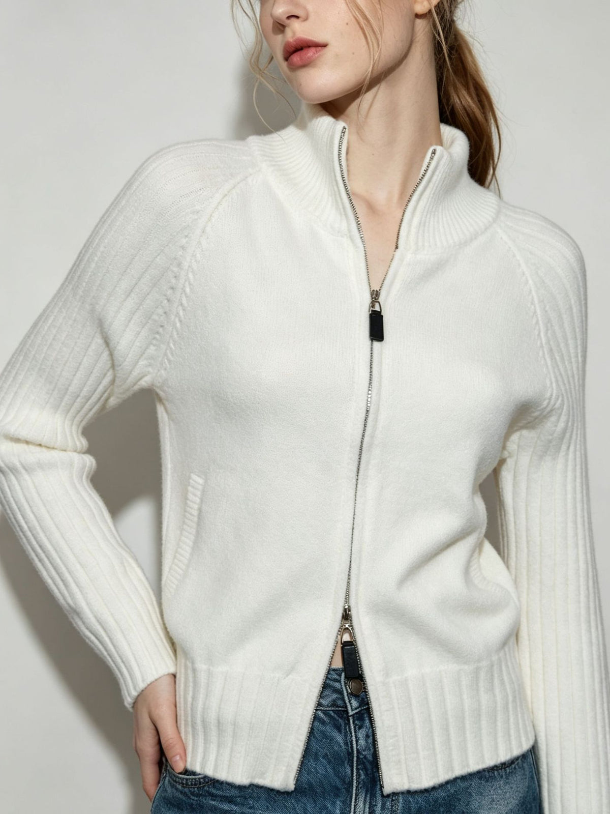 Women's white ribbed knit zip-up sweater jacket with stand collar and front zipper.