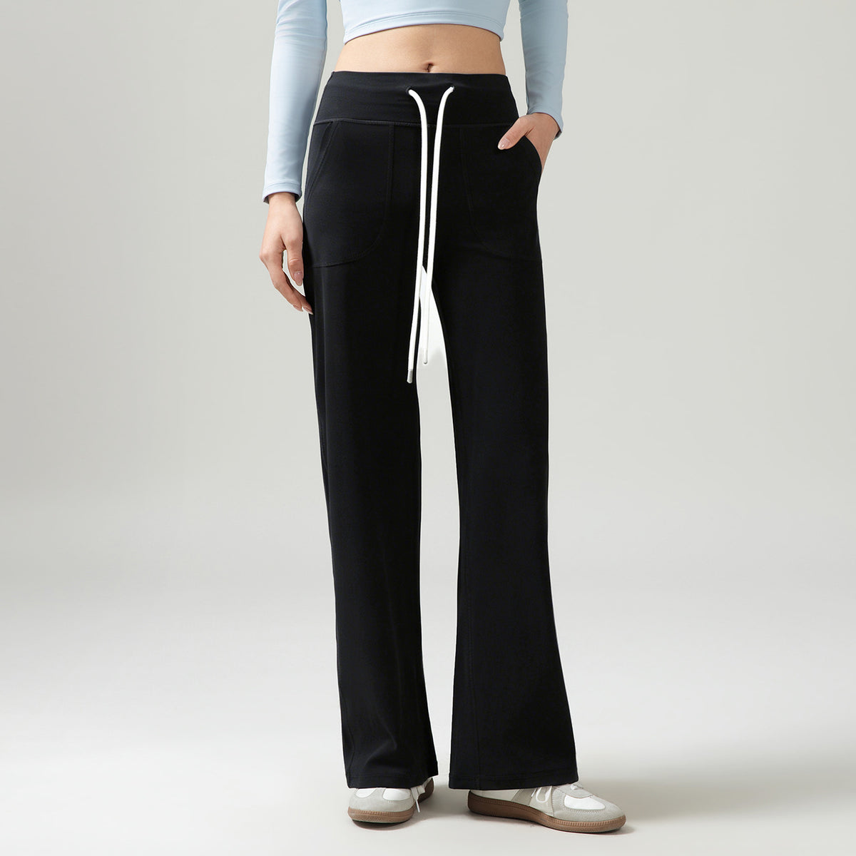 Women’s high-waisted wide-leg pants with drape, black, side drawstring ties and front pockets.