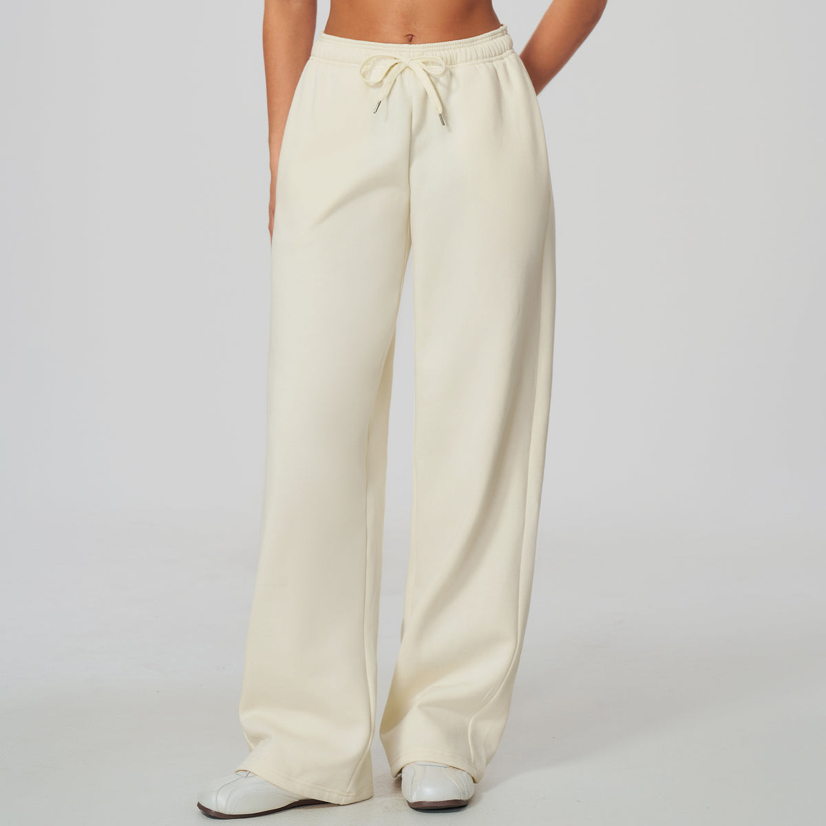 Off-white high-waisted sweatpants with elastic waistband and drawstring, wide legs