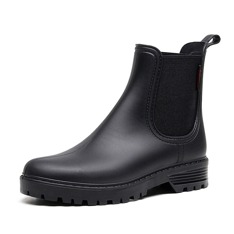Black Chelsea rain boot with elastic side panel, thick sole tread, and heel pull loop