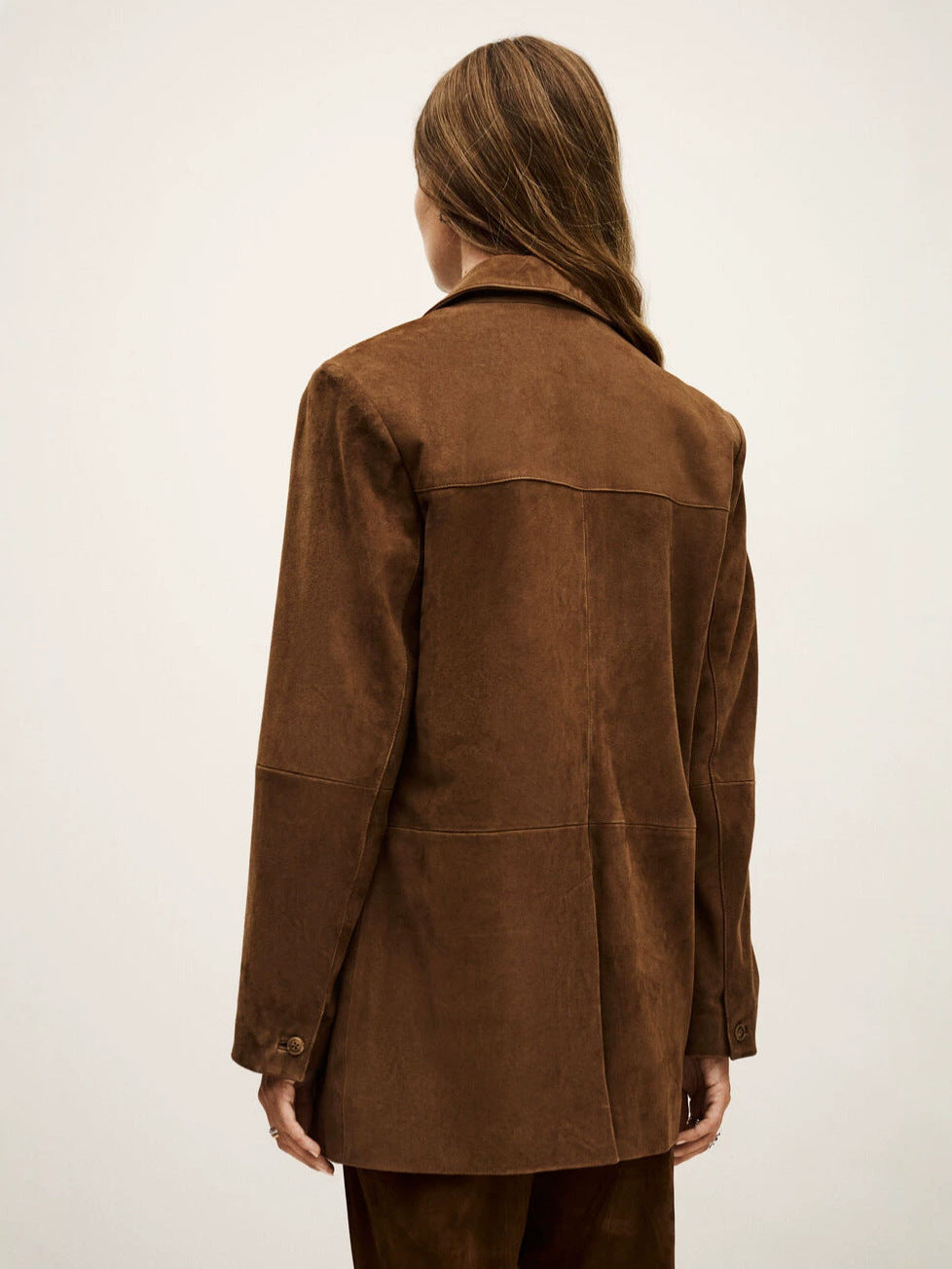 Back view of brown suede blazer with panel seams and buttoned cuffs
