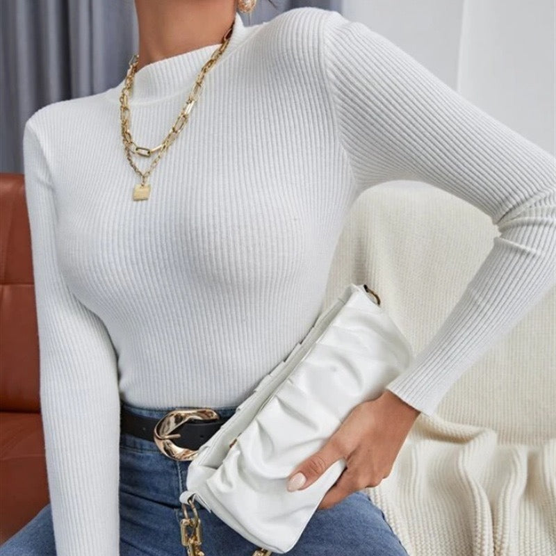 White ribbed mock neck long-sleeve knit top with fitted sleeves.