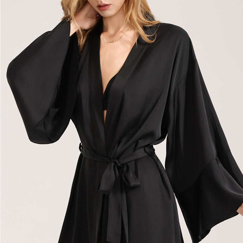Black satin robe close-up with V-neck, waist tie belt, and wide flowing sleeves