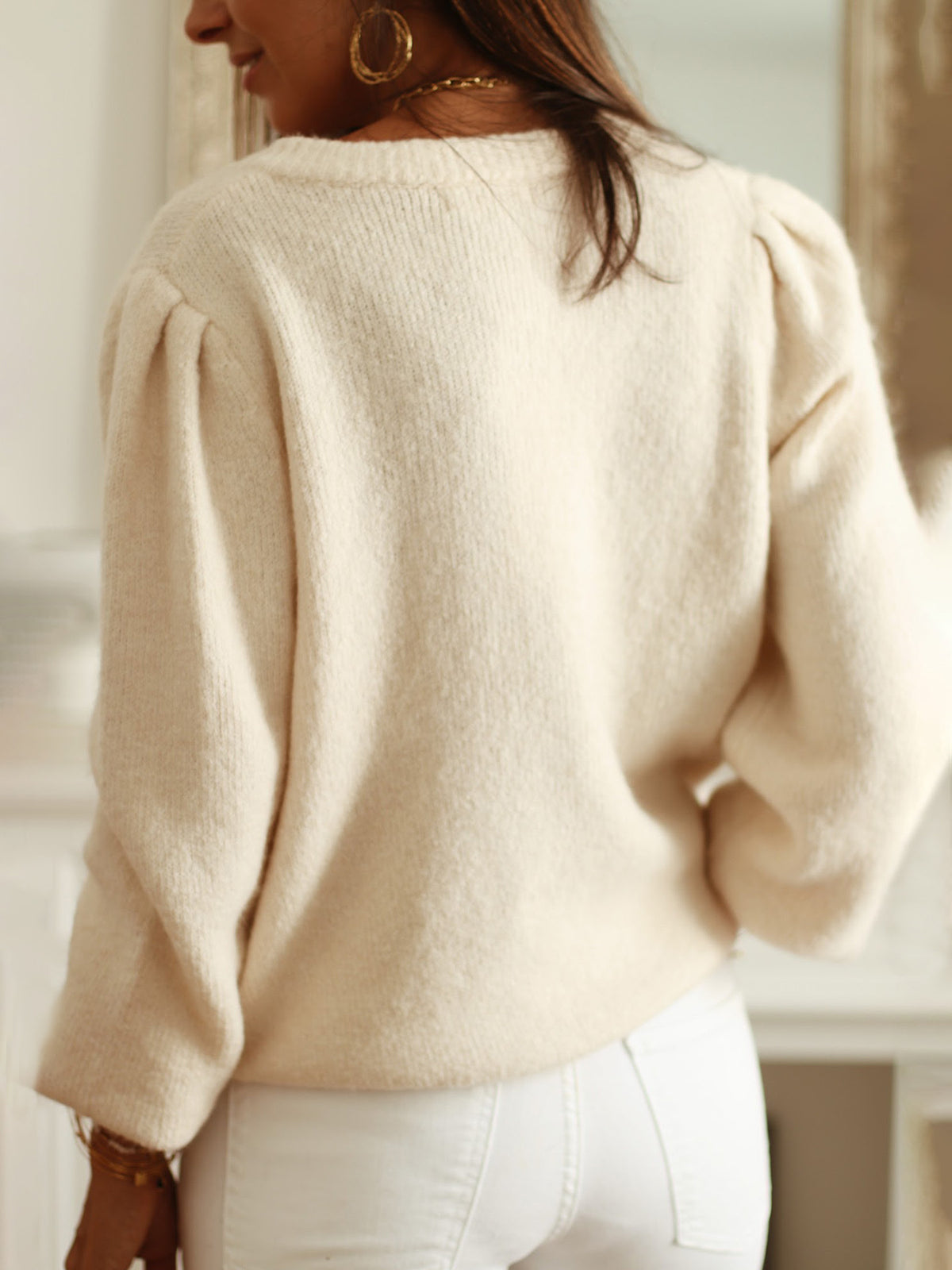 Back view of a cream knit cardigan with puff sleeves and a plain body