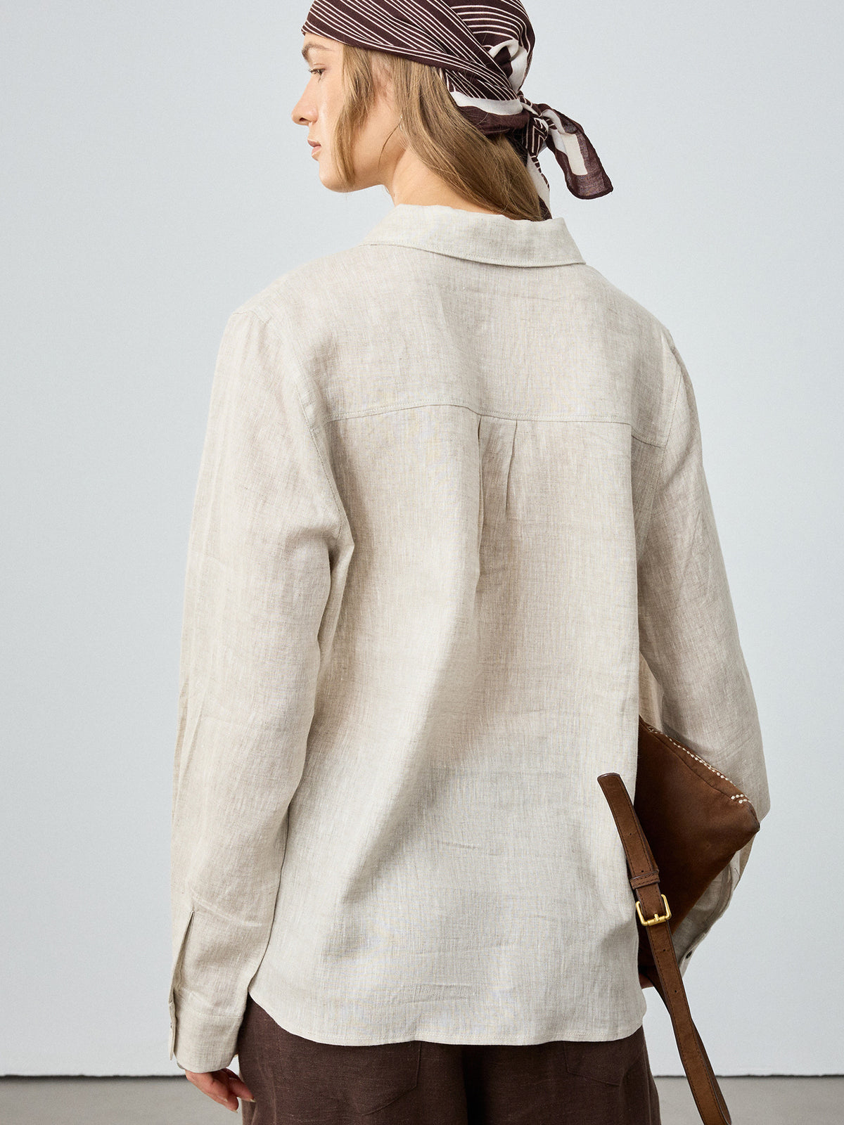 Women’s off-white linen button-up shirt, back view, long sleeves and pocketed back yoke